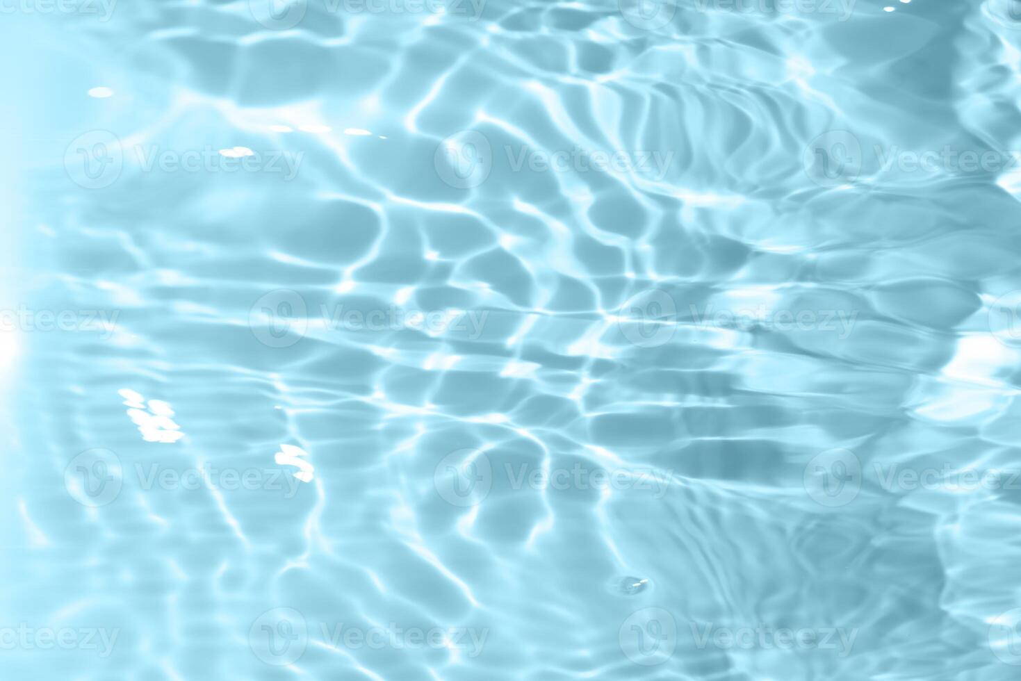 Bluewater waves on the surface ripples blurred. Defocus blurred transparent blue colored clear calm water surface texture with splash and bubbles. Water waves with shining pattern texture background. photo