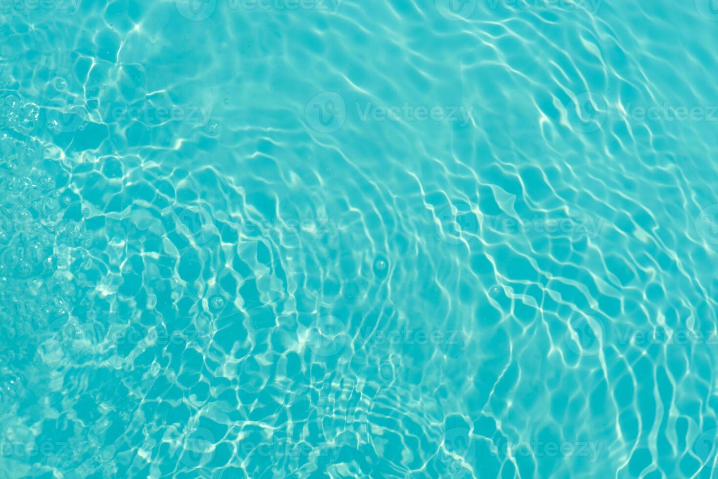 Bluewater waves on the surface ripples blurred. Defocus blurred transparent blue colored clear calm water surface texture with splash and bubbles. Water waves with shining pattern texture background. photo