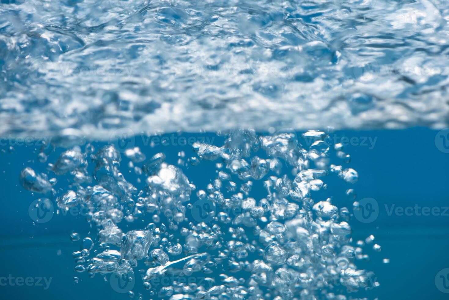 Bluewater waves on the surface ripples blurred. Defocus blurred transparent blue colored clear calm water surface texture with splash and bubbles. Water waves with shining pattern texture background. photo