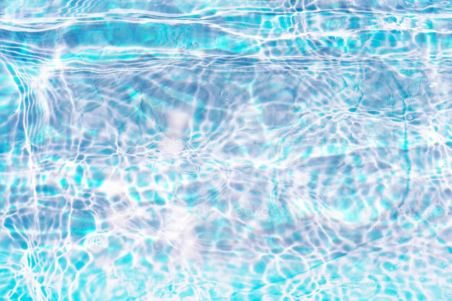 Bluewater waves on the surface ripples blurred. Defocus blurred transparent blue colored clear calm water surface texture with splash and bubbles. Water waves with shining pattern texture background. photo