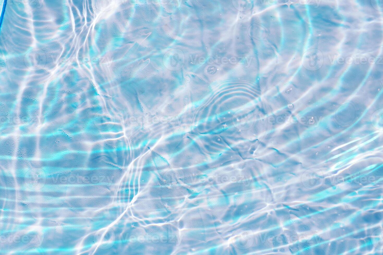 Bluewater waves on the surface ripples blurred. Defocus blurred transparent blue colored clear calm water surface texture with splash and bubbles. Water waves with shining pattern texture background. photo
