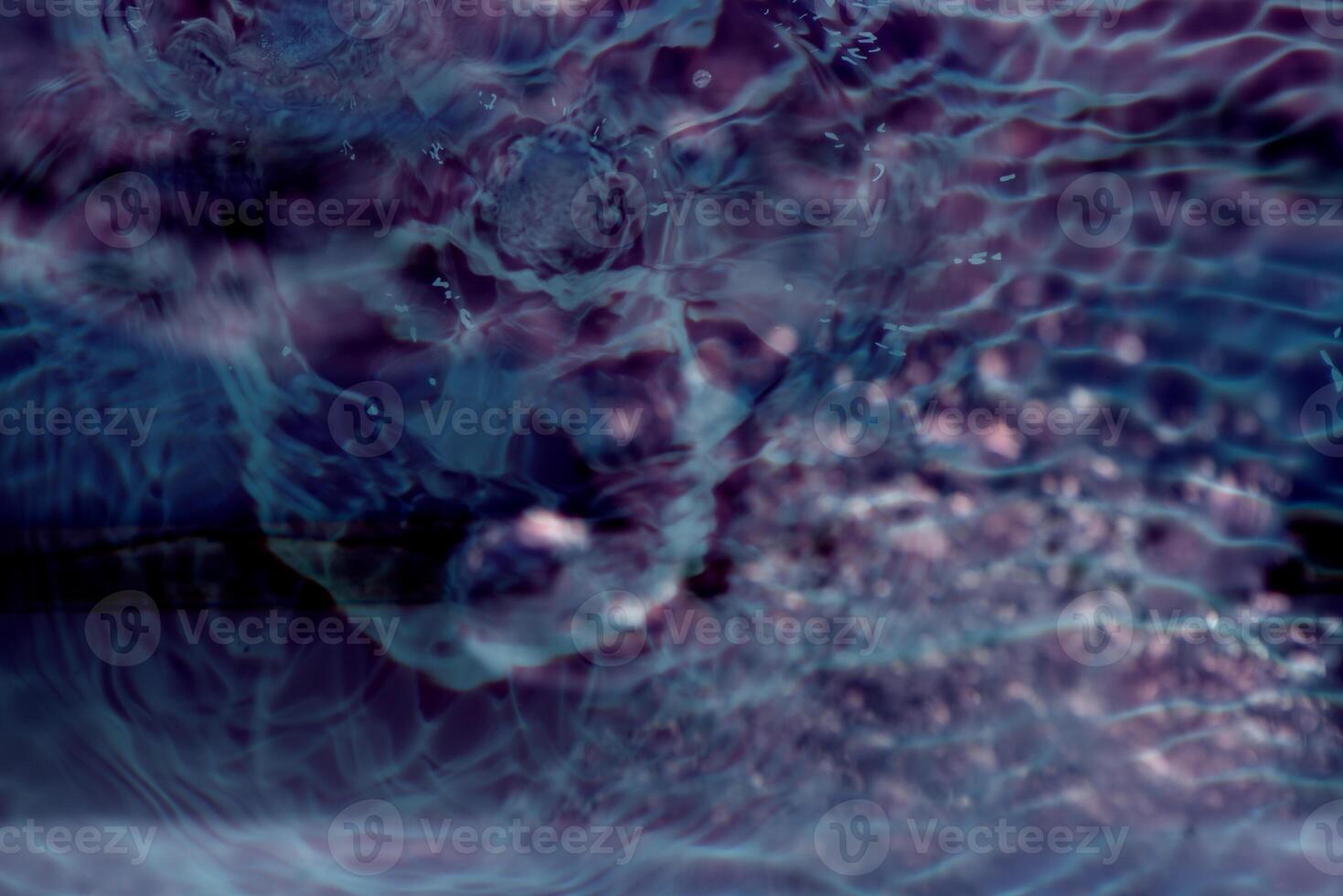 Bluewater waves on the surface ripples blurred. Defocus blurred transparent blue colored clear calm water surface texture with splash and bubbles. Water waves with shining pattern texture background. photo