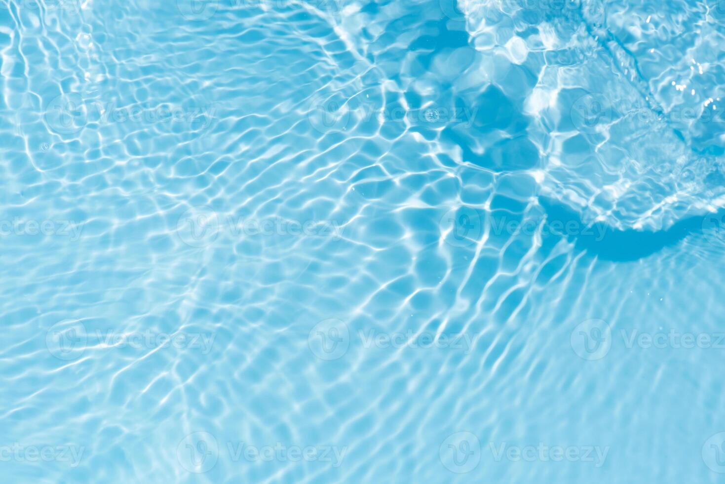 Bluewater waves on the surface ripples blurred. Defocus blurred transparent blue colored clear calm water surface texture with splash and bubbles. Water waves with shining pattern texture background. photo