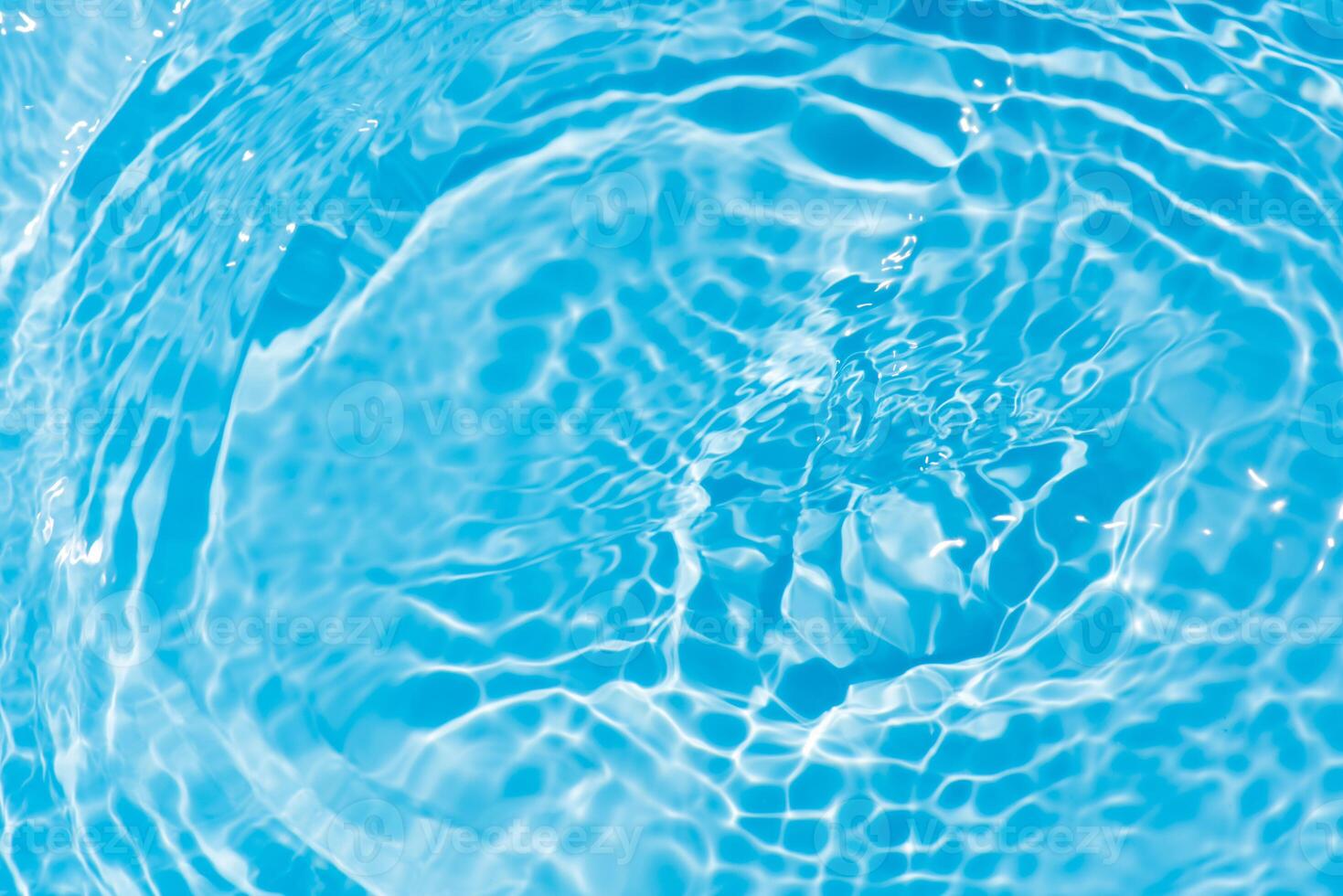 Bluewater waves on the surface ripples blurred. Defocus blurred transparent blue colored clear calm water surface texture with splash and bubbles. Water waves with shining pattern texture background. photo