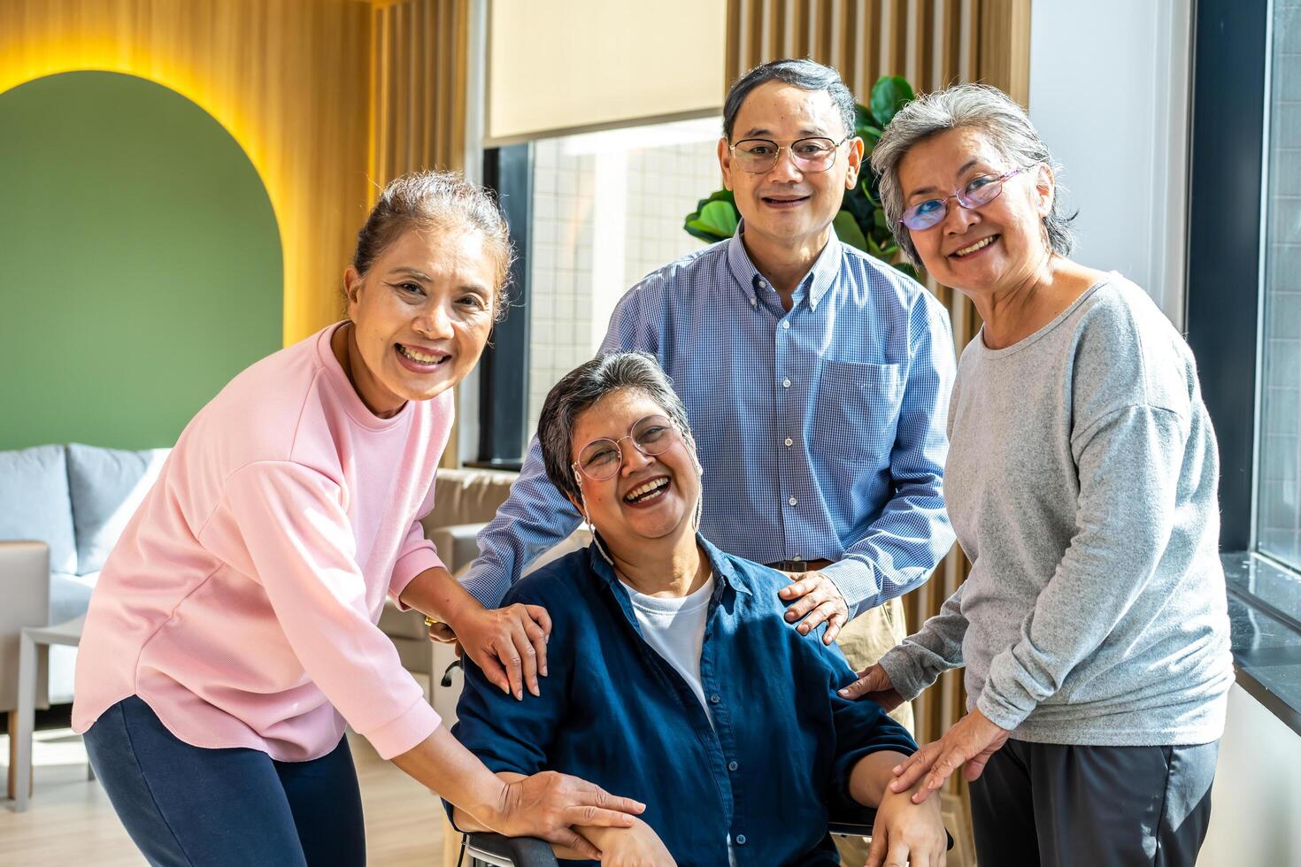 Group of asia happy retired senior people enjoy standing relax at hospital, portrait of asian senior male female friend group sit of wheelchair smiling together and look at camera photo