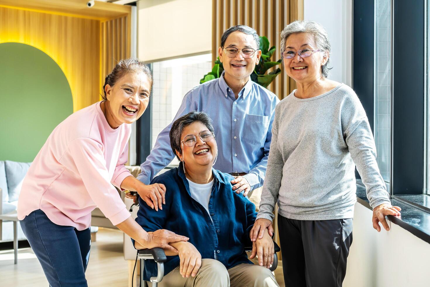 Group of asia happy retired senior people enjoy standing relax at hospital, portrait of asian senior male female friend group sit of wheelchair smiling together and look at camera photo