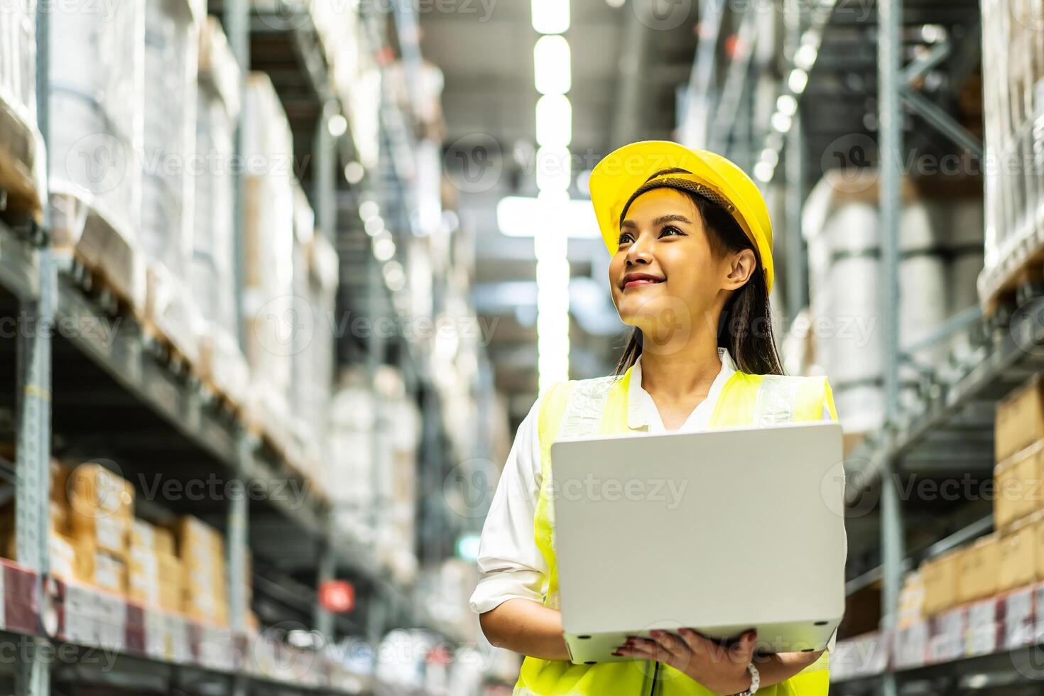 Smiling asian woman warehouse worker doing stocktaking of products management in cardboard box on shelves in warehouse using laptop computer, logistic and business export photo
