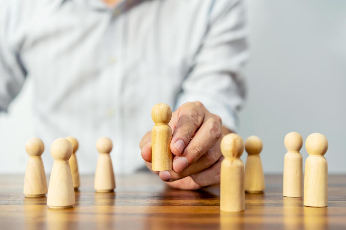 Concept Human resources search block wooden, Personnel selection represented by a hand choosing a stylized person from a group of people, Conceptual of planning, strategy photo