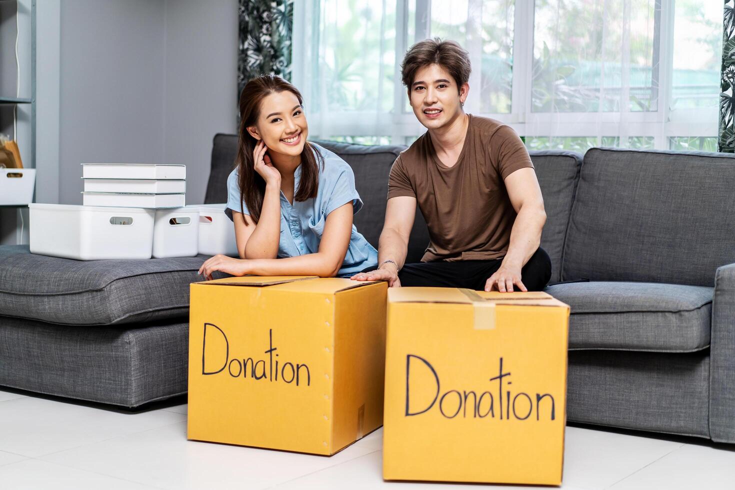 Portrait of a happy young couple packing stuff clothes, object charity in cardboard box, reused for donate, Product recycle or volunteer sharing donation concept. photo