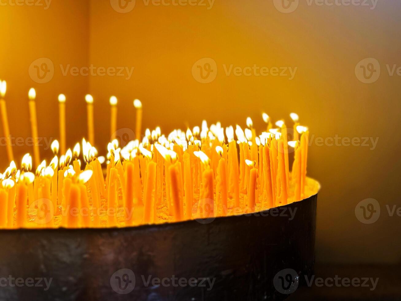 A real view of a burning candle in a church. In a special big candlestick with candle, photo
