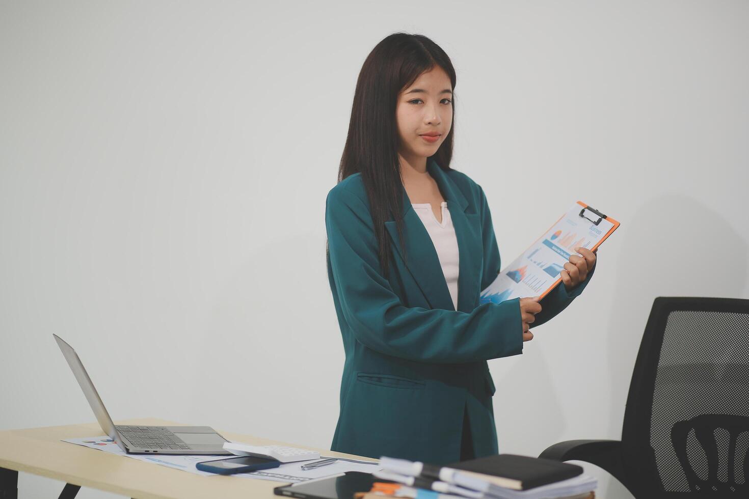 Asian Business woman using calculator and laptop for doing math finance on an office desk, tax, report, accounting, statistics, and analytical research concept photo
