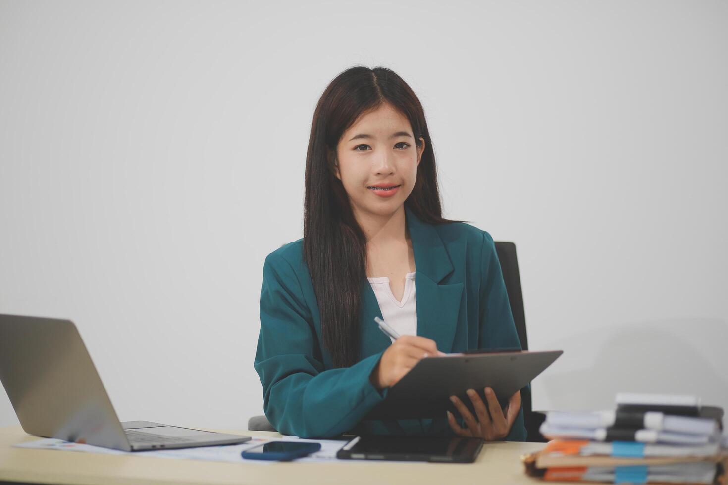 Asian business woman working using laptop computer, marketing report with calculator document on table Planning to analyze financial reports Investing in an online business plan, e-commerce. photo