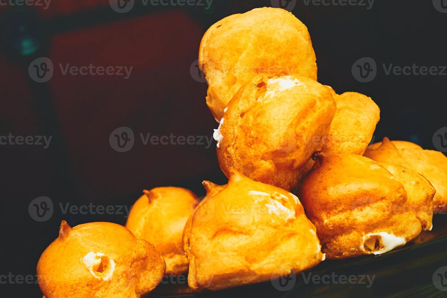 Tasty baked cakes eclairs profiteroles with cream photo
