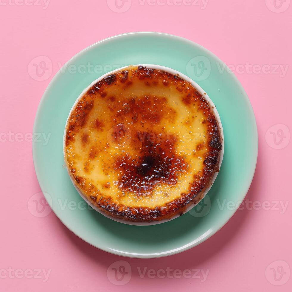 Creme brulee on blue plate with pink background. photo