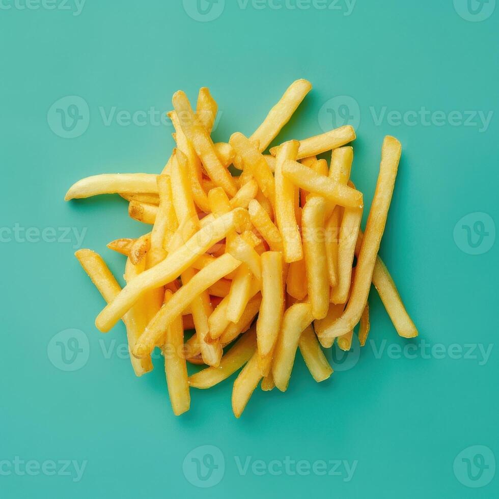 Golden French Fries on Turquoise Background photo
