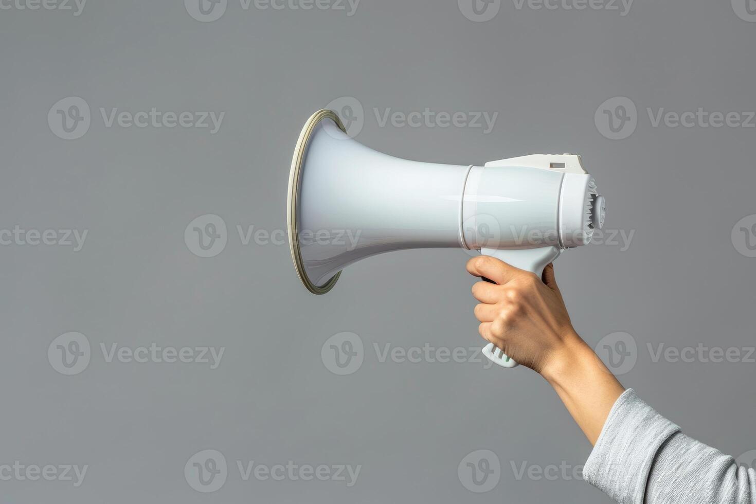 Hand holding a megaphone on a gray background photo
