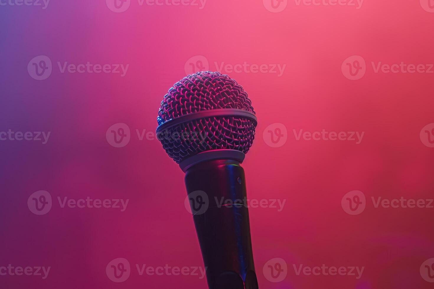 Close up of a black microphone against a pink and blue gradient background photo