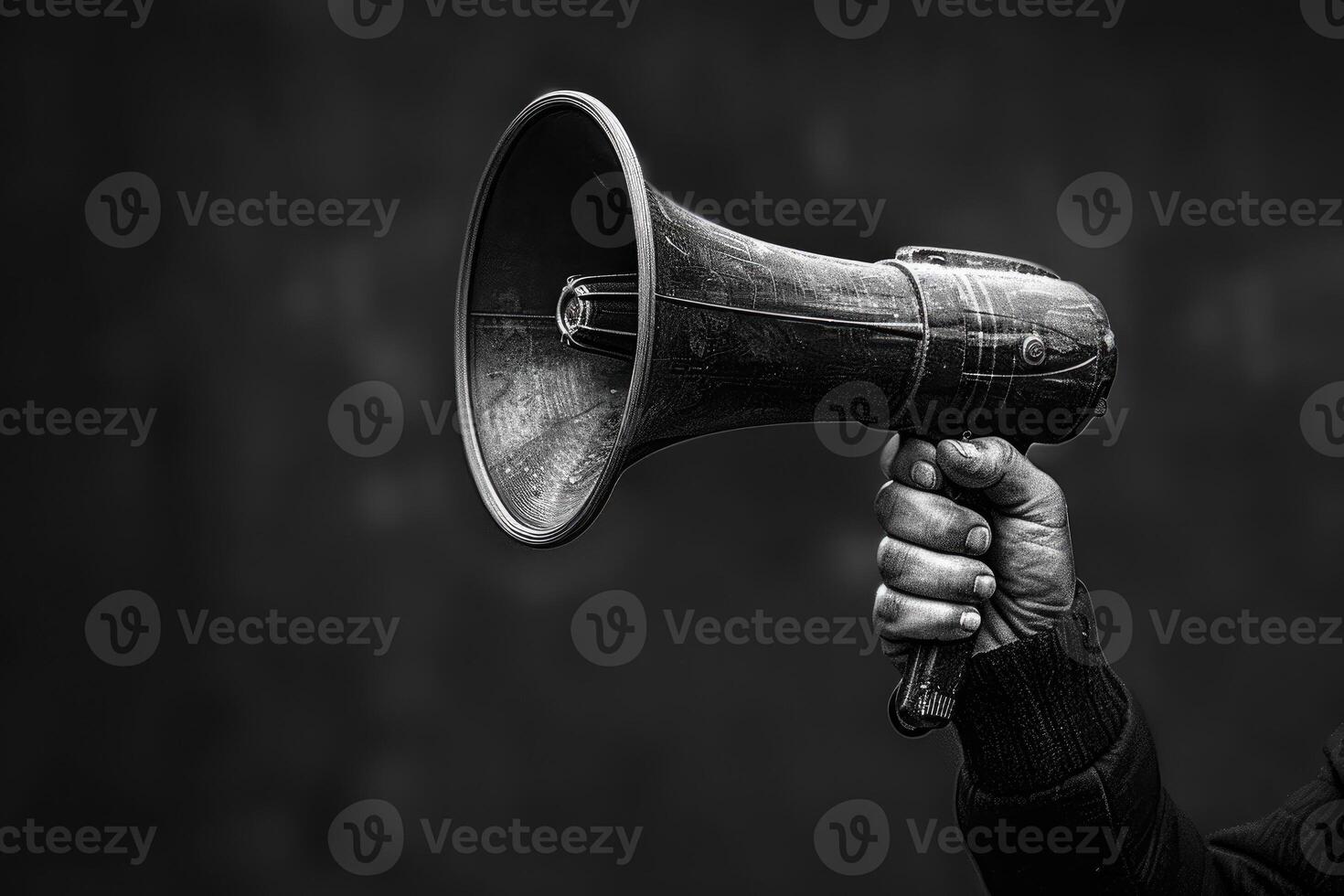 Hand holding a vintage megaphone with a dark background photo