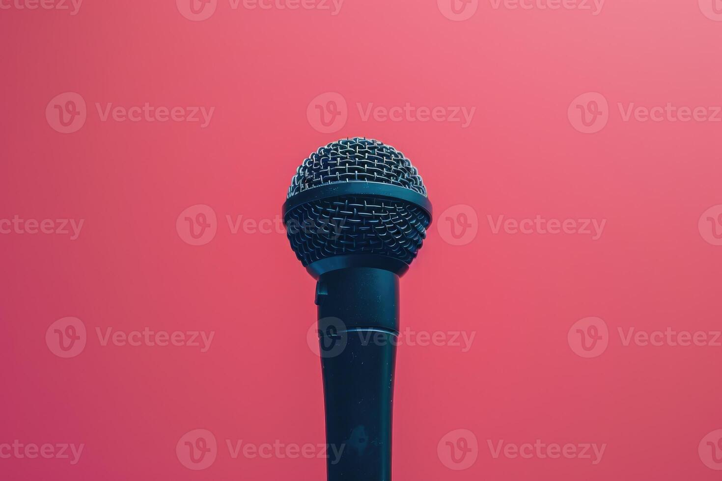 Closeup of a black microphone against a pink background photo