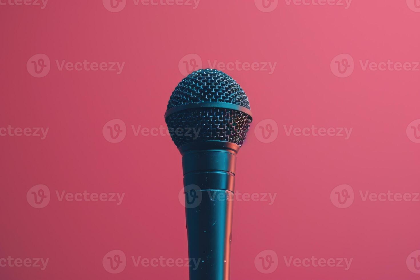 Close up of a microphone on stage with pink background lights photo