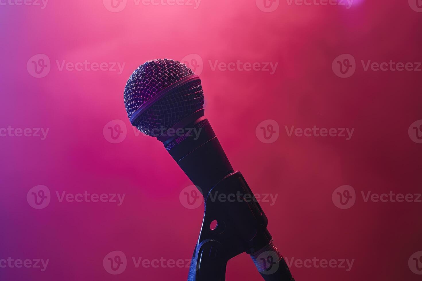 Close up of a microphone on stage with a pink background photo