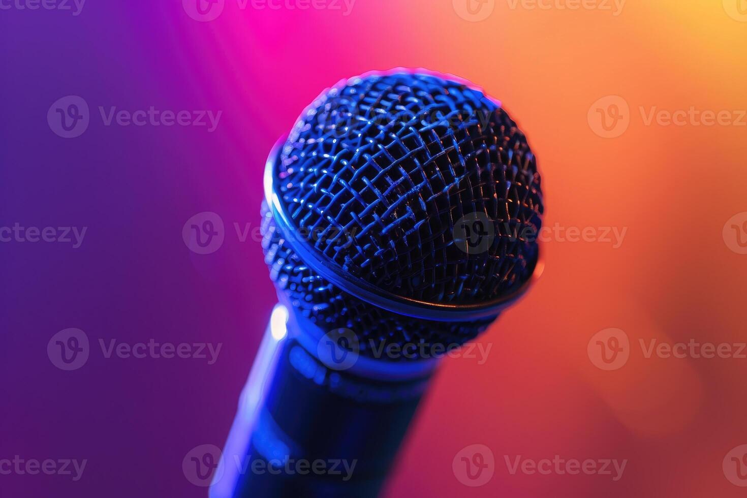 Close up of a professional dynamic microphone on stage with colorful blurred background lights photo