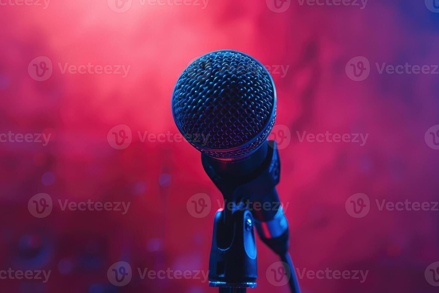 Close up of a microphone on stage with red and blue lighting photo