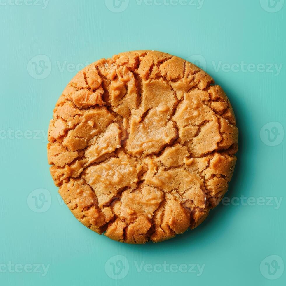 Single peanut butter cookie isolated on blue background. Close-up view of a delicious homemade peanut butter cookie. photo