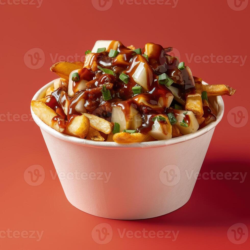 Close-up of a delicious poutine dish in a white bowl with fries, cheese curds, gravy and green onions. photo