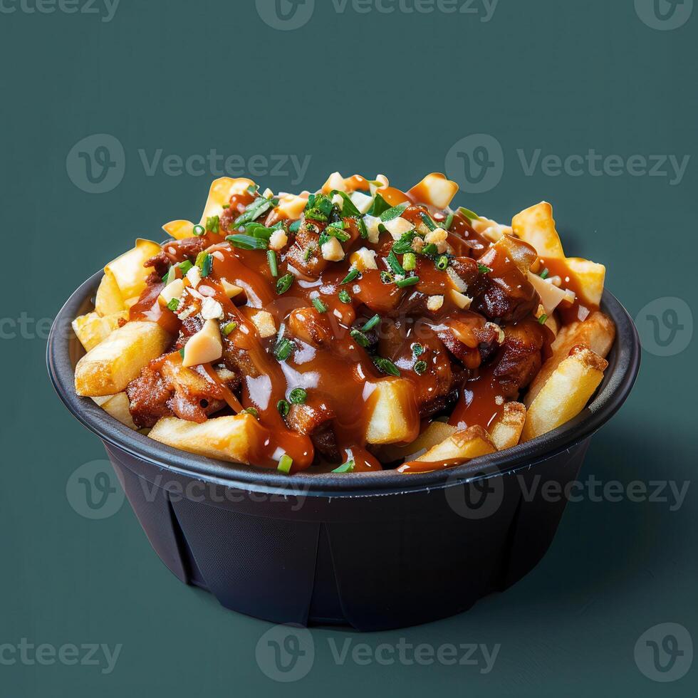 Delicious Poutine with Gravy, Cheese Curds and Toppings in Black Bowl on Green Background photo