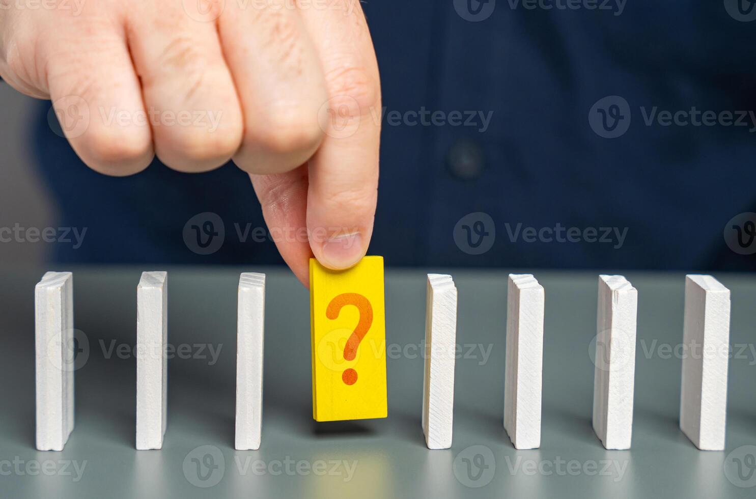 A man studies an unknown element of a chain of processes in the form of dominoes. Finding an answer to a question. Mistake correction. The fact remains in question. An unknown issue photo