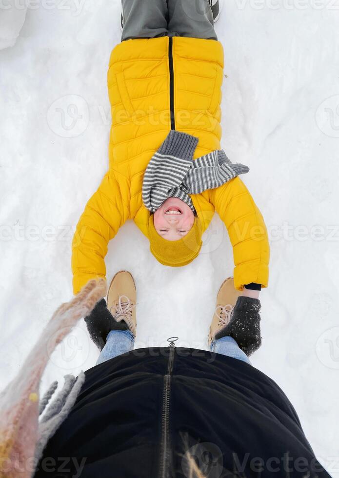 Top View on Laughing Kid Lying on Snow photo