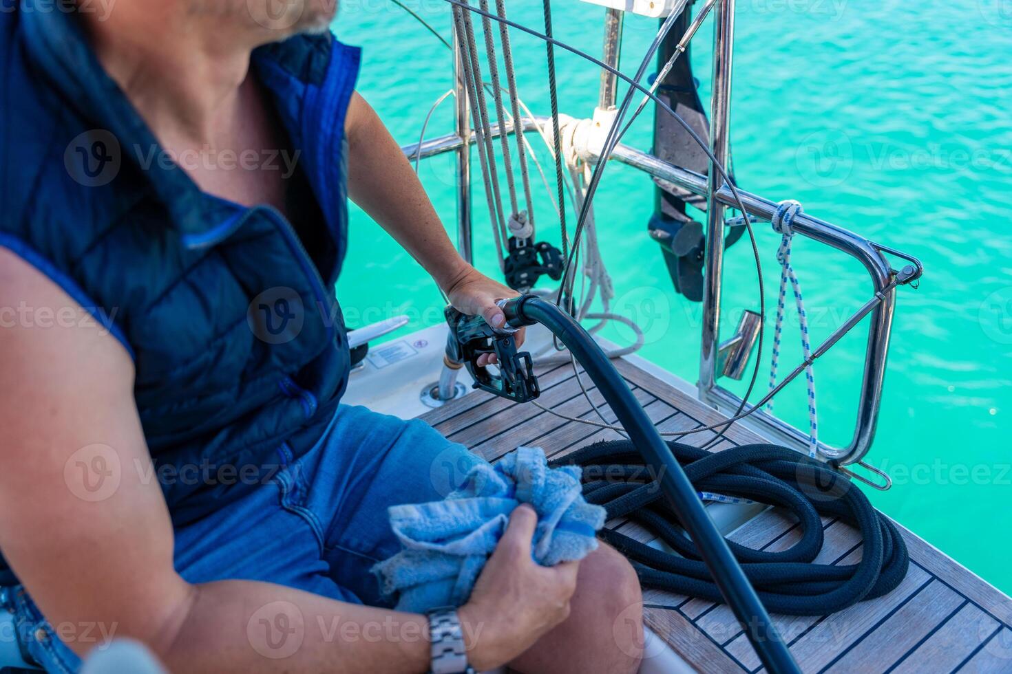 A man holds a petrole pistol and pours gasoline into a yacht on gas petrol station near sea for ship, boats and yachts in Rogoznica, Croatia. View from the yacht deck. High quality photo