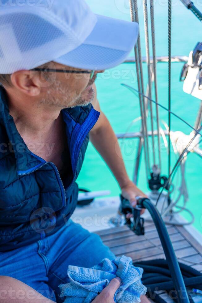 A man holds a petrole pistol and pours gasoline into a yacht on gas petrol station near sea for ship, boats and yachts in Rogoznica, Croatia. View from the yacht deck. High quality photo