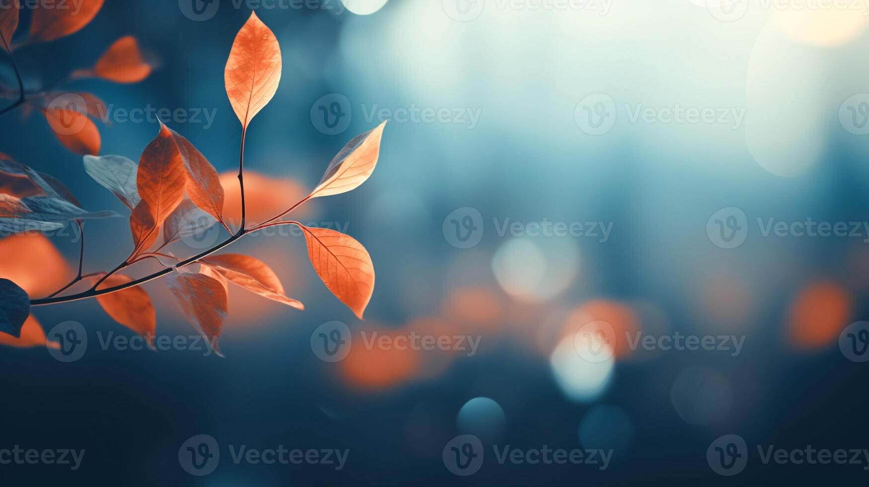 blurred background of orange leaves with bokeh on a blue background photo
