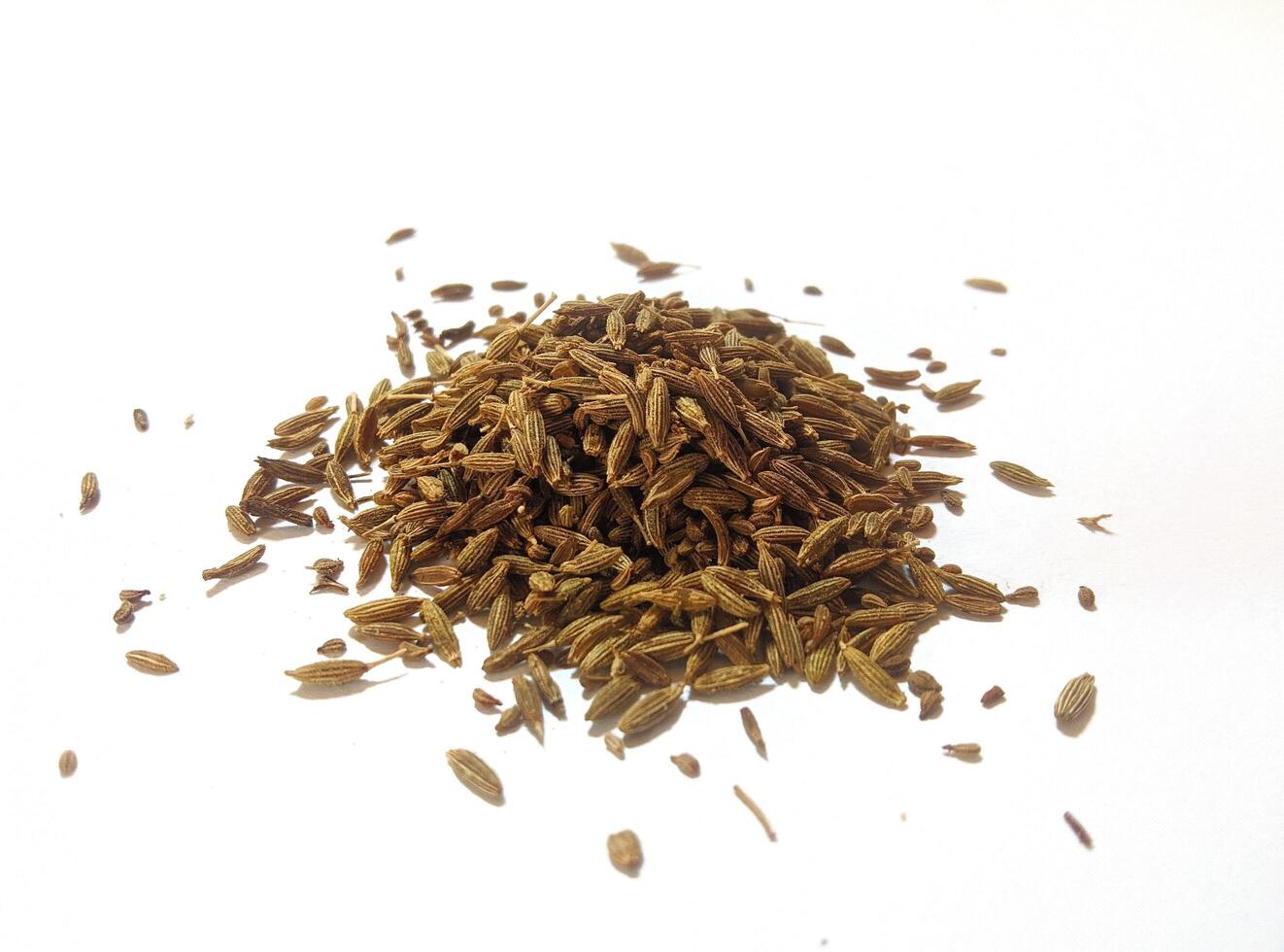 Pile of cumin seeds isolated on white background photo
