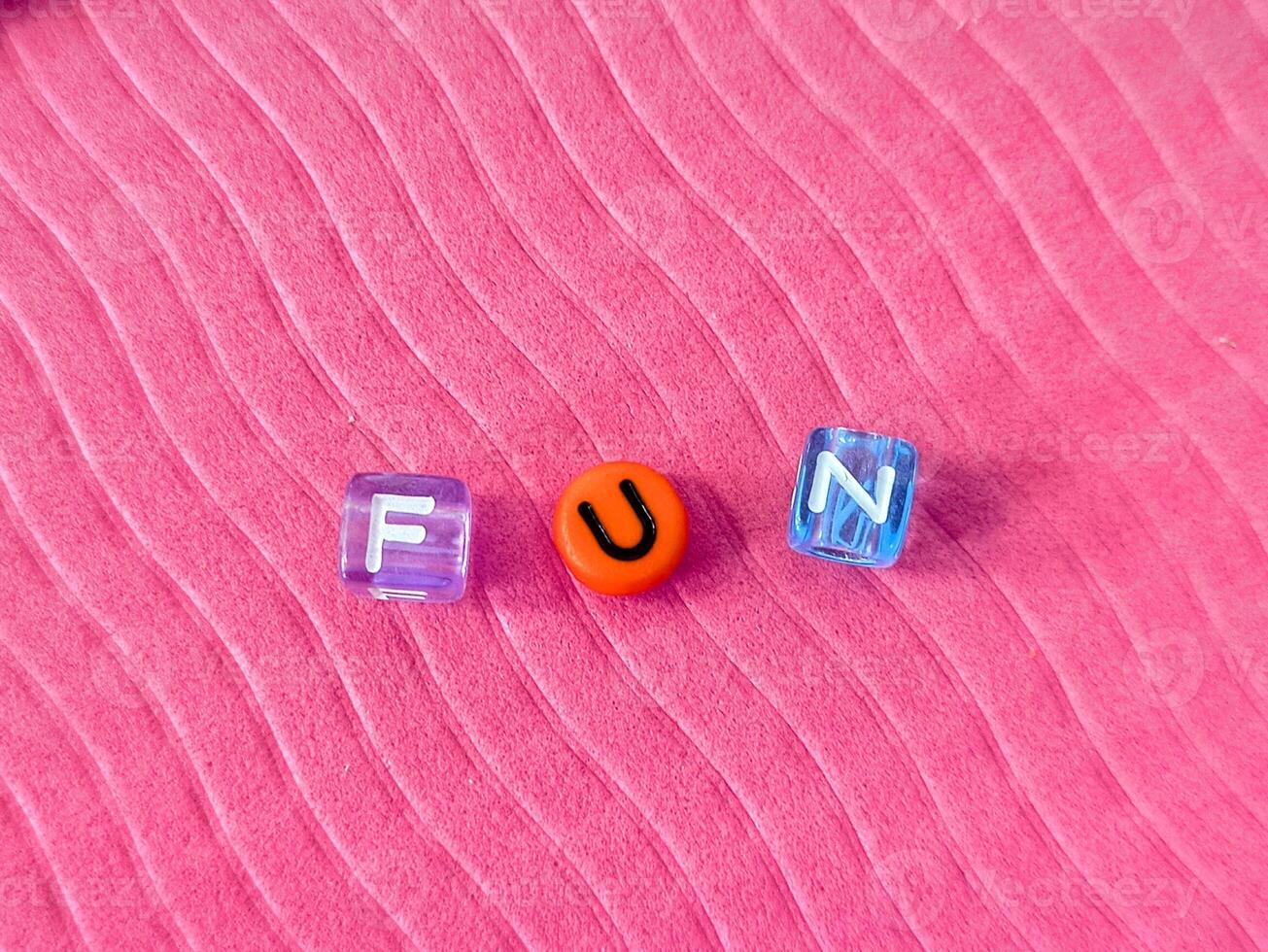 The word www formed with multicolored plastic cubes on pink background photo