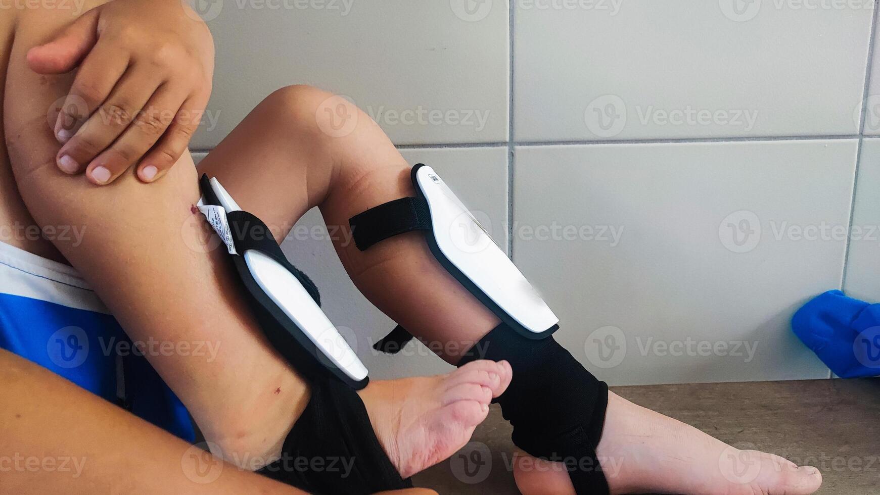 Close-up of a boy soccer player putting on soccer pads in the locker room. Equipment for young soccer players before training. photo