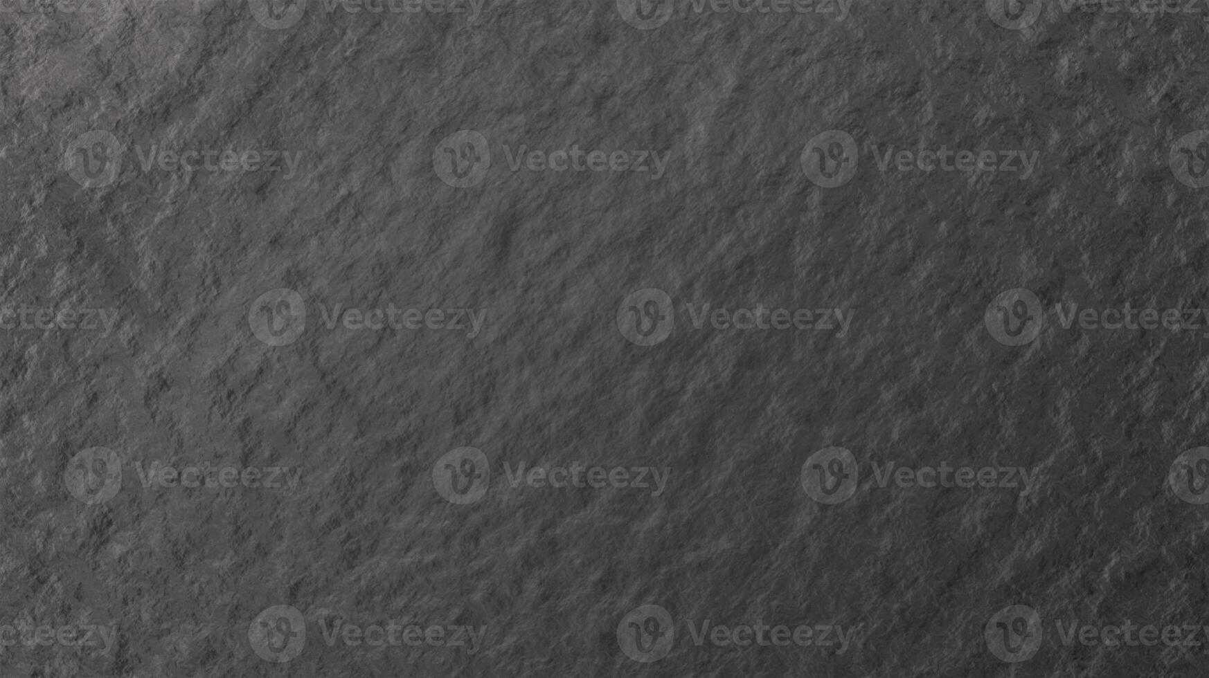 Close-up view of a dark gray slate texture, showcasing its natural, rough surface with subtle variations in shade and texture. The image highlights the stone's rugged and organic feel. photo