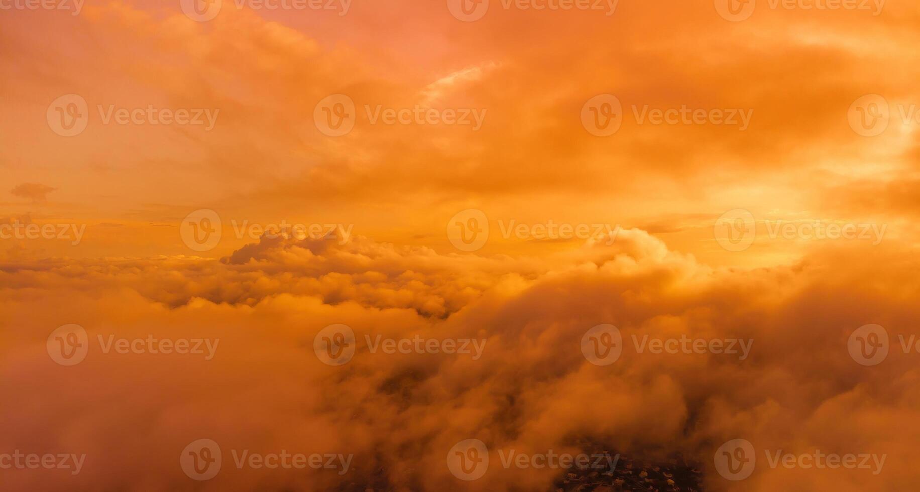 A red burning sunset over the sea with rocky volcanic cliff. Abstract nature summer or spring ocean sea background. Small waves on golden warm water surface with bokeh lights from sun. photo