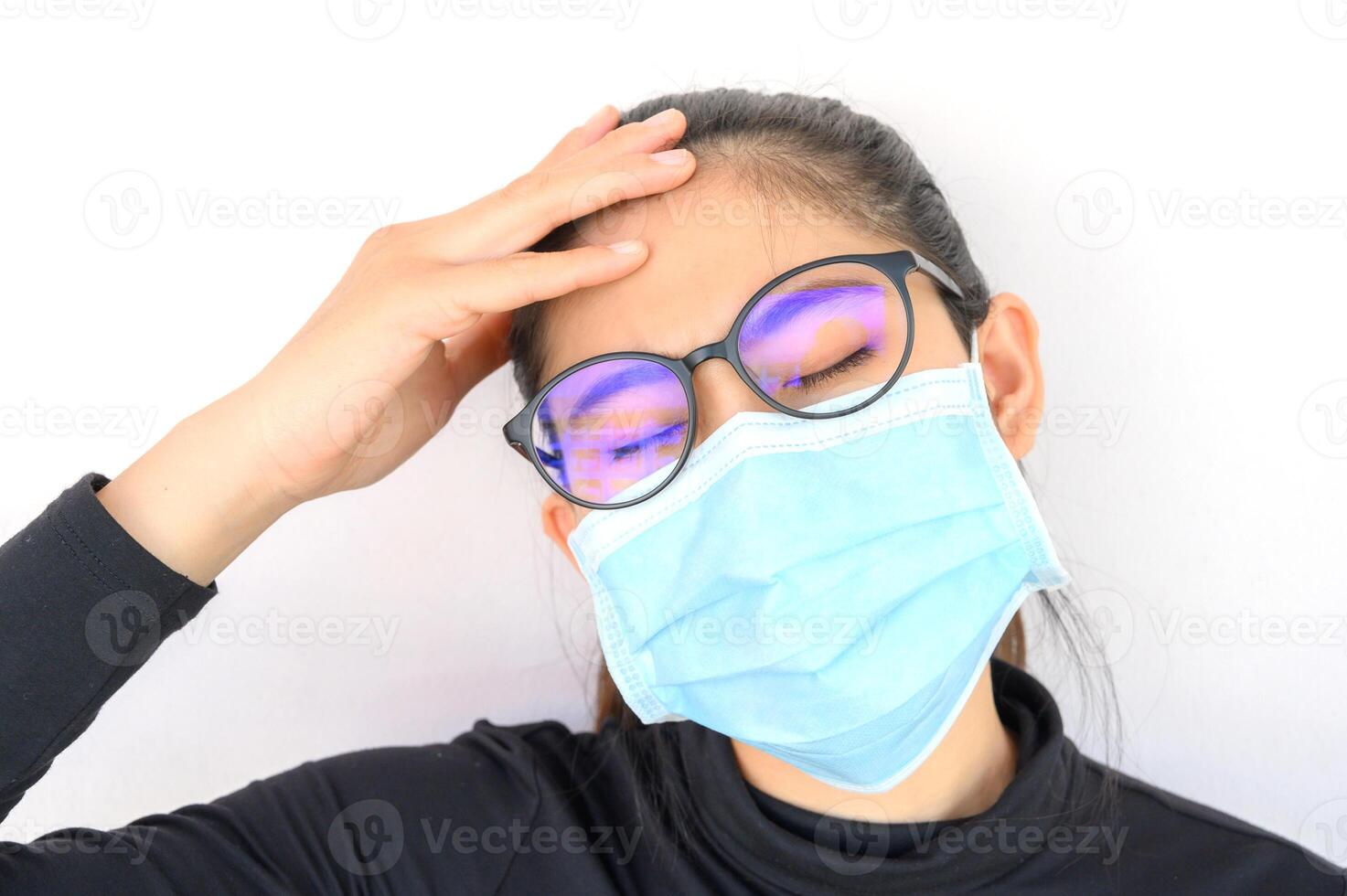 Young Asian woman feel headache and wearing medical mask for protect bad air pollution. Air pollution has been associated with diseases of the heart and lungs, cancers and other health problems. photo
