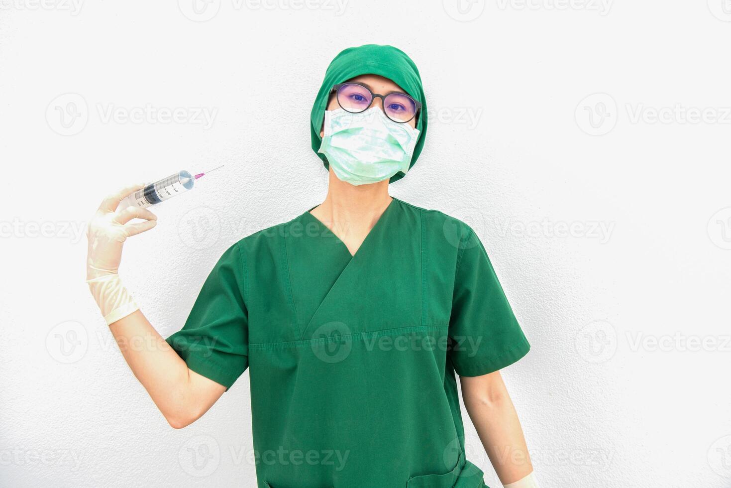 Portrait of young surgery nurse or doctor acting madness and trying to injecting herself with a syringe into a blood vessel at her neck. Healthcare worker and Medical concept. photo