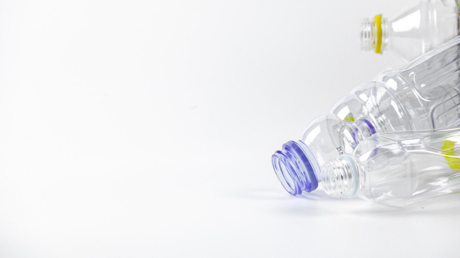 Clear plastic bottles on a white surface, awaiting recycling. photo