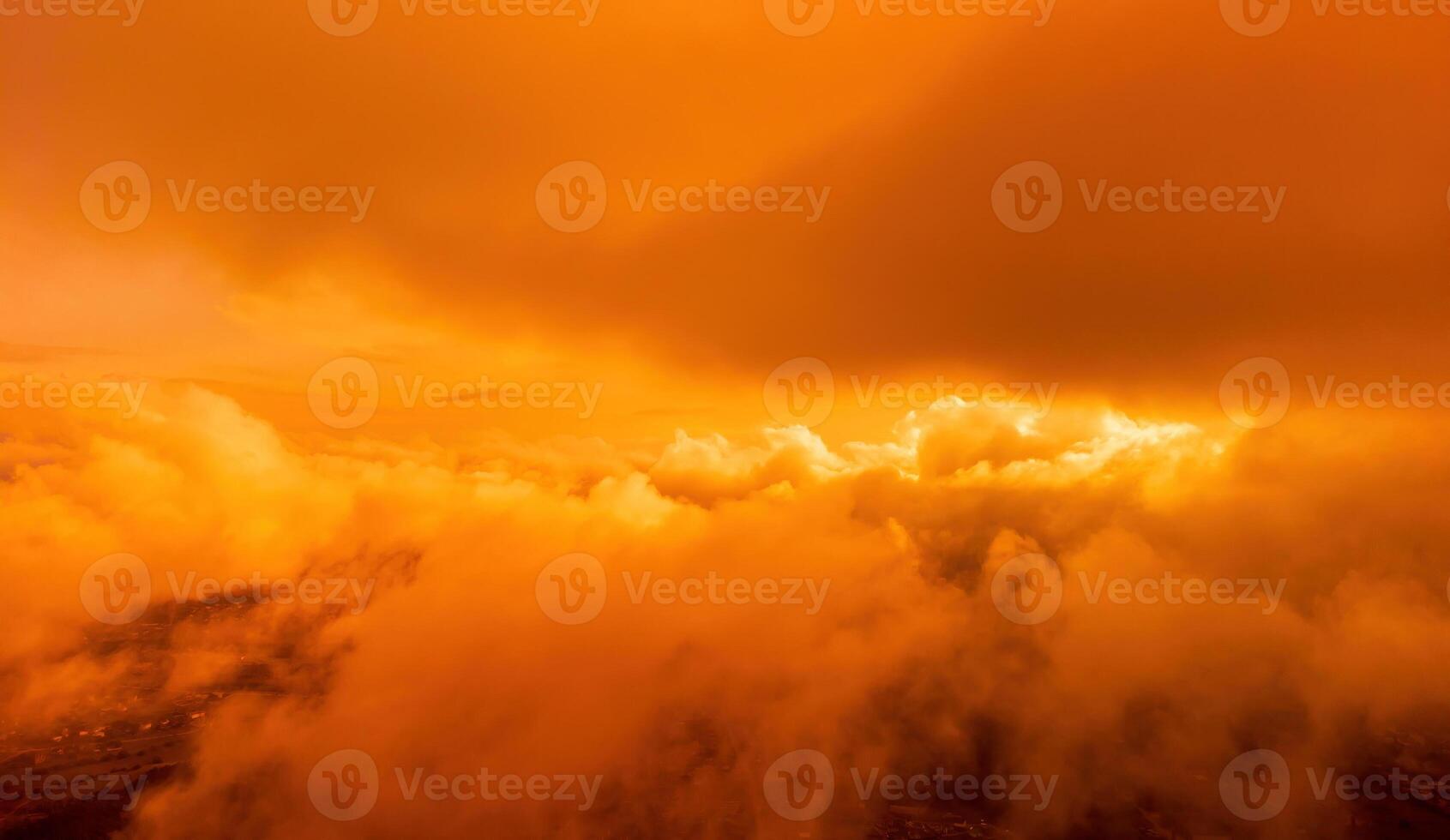 A red burning sunset over the sea with rocky volcanic cliff. Abstract nature summer or spring ocean sea background. Small waves on golden warm water surface with bokeh lights from sun. photo