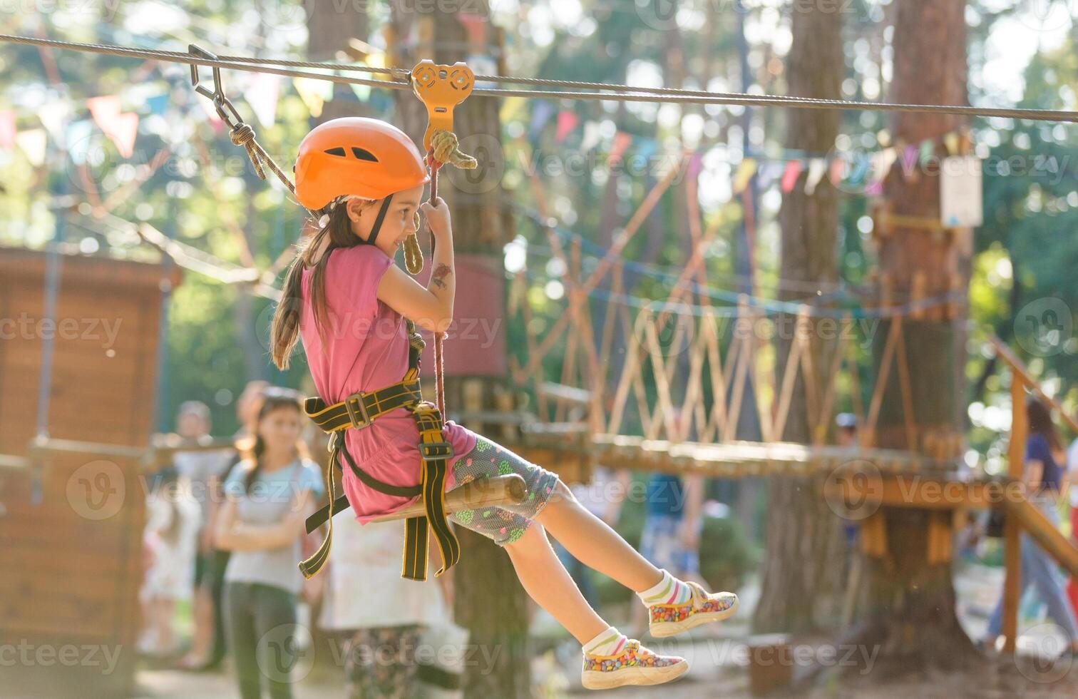 Smiling little girl on the playground, climbing rope net photo