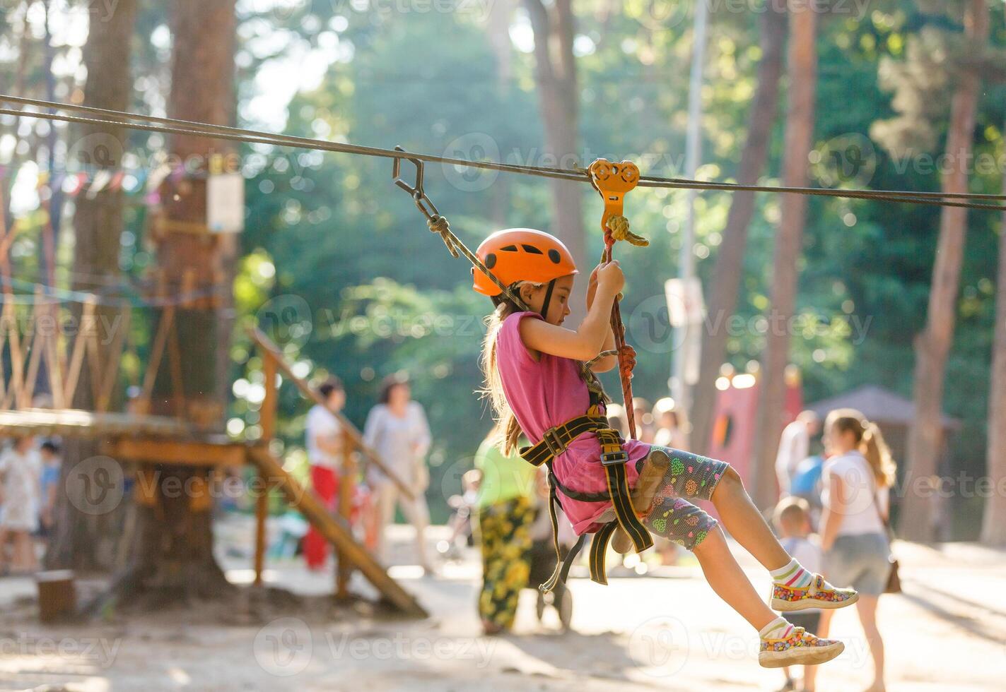 Smiling little girl on the playground, climbing rope net photo