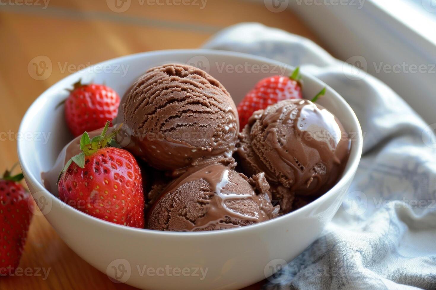 Chocolate ice cream scoops melting in a bowl and topped with strawberries photo