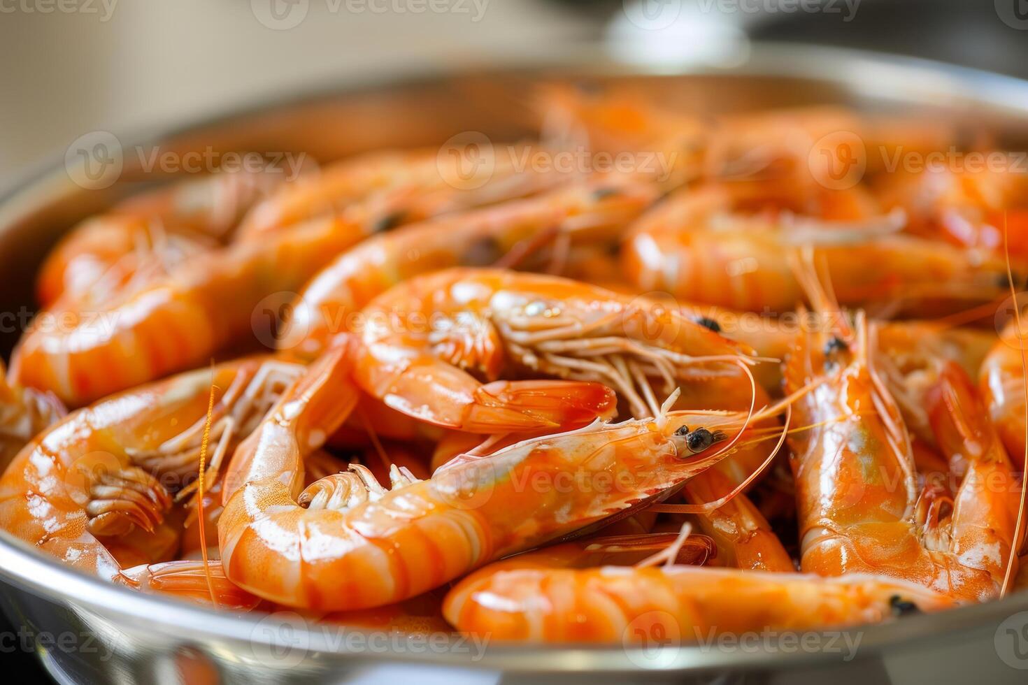 Cooked tiger prawns piled up in stainless steel bowl photo