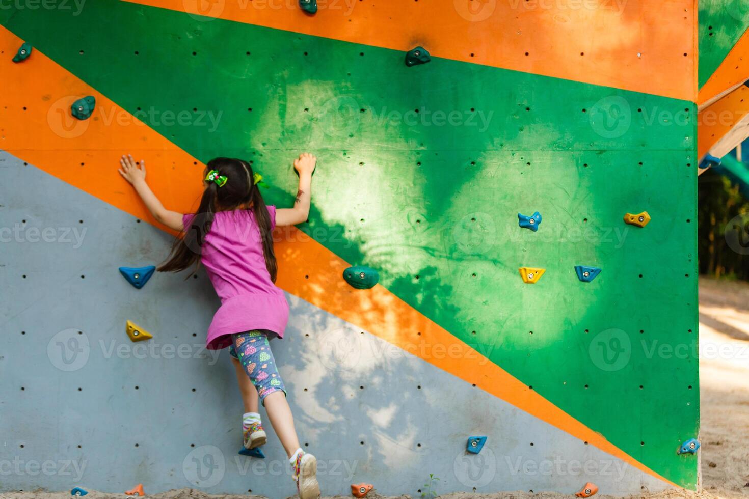 happy little girl in a rope park on the wood background photo