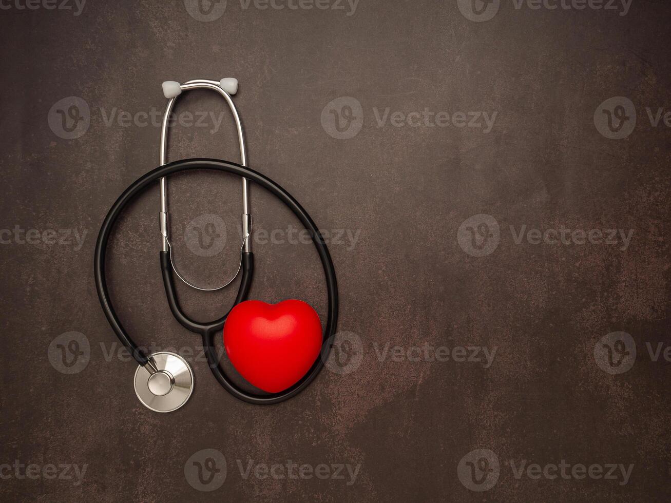 A stethoscope and red heart on vintage background. Close-up photo. Top view. Flat lay. Space for text. Healthcare and medicine concept photo